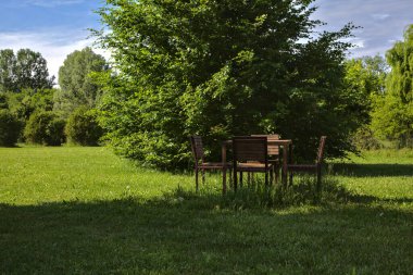 Kırsal kesimdeki bir parkta sandalyeli yemek masası.