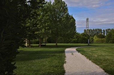 Güneşli bir günde, baharda İtalya kırsalındaki bir parkta çakıl yolu.