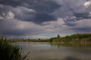 İtalya kırsalında bulutlarla dolu açık bir günde nehir