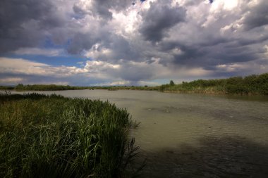 İtalya kırsalında bulutlarla dolu açık bir günde nehir