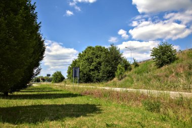 Açık bir yaz gününde, İtalya kırsalında bir kavşağın çıkışında.