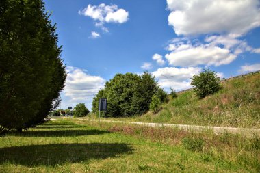 Açık bir yaz gününde, İtalya kırsalında bir kavşağın çıkışında.