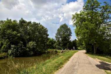 Yazın İtalya kırsalında bir su deresinin yanında bisiklet yolu.
