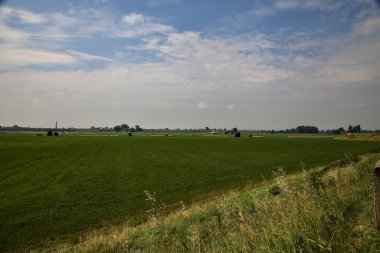 İtalya kırsalında bir yaz günü gün ortasında saman balyalarıyla tarlalar