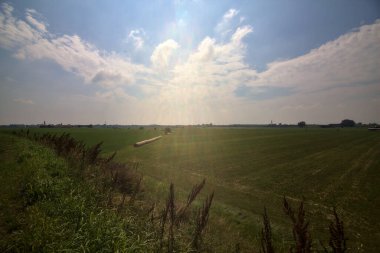 İtalya kırsalında bir yaz günü gün ortasında saman balyalarıyla tarlalar