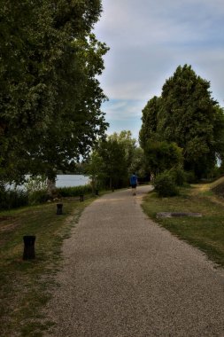 Gün batımında gölün kıyısındaki parkta bisiklet yolu.