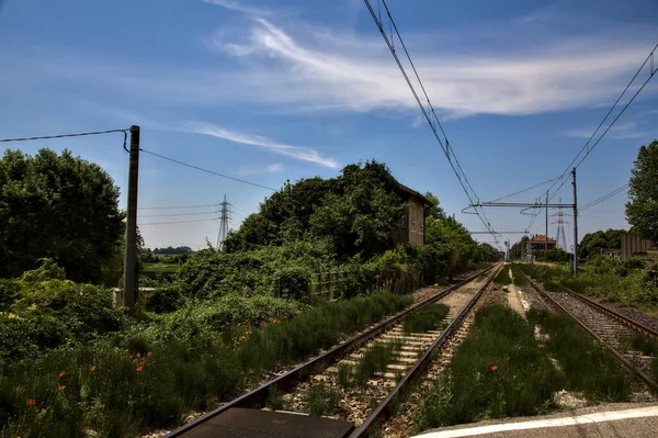 Railroad crossing in the italian countryside at midday in summer