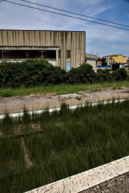 Yazın İtalya kırsalında bir demiryolunun yanında terk edilmiş bir yerleşke.