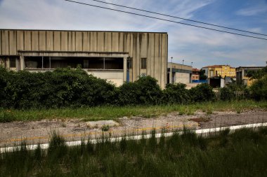 Yazın İtalya kırsalında bir demiryolunun yanında terk edilmiş bir yerleşke.