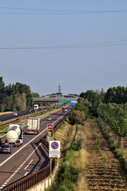 Kırsal kesimdeki İtalyan otoyolu yazın günbatımında bir köprünün üstünden görülüyor.