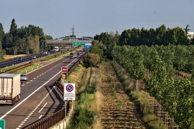 Kırsal kesimdeki İtalyan otoyolu yazın günbatımında bir köprünün üstünden görülüyor.