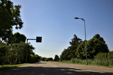 Yazın açık bir günde İtalya kırsalında boş bir yol.