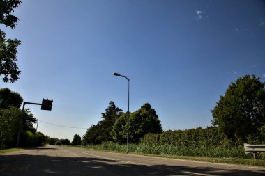 Yazın açık bir günde İtalya kırsalında boş bir yol.