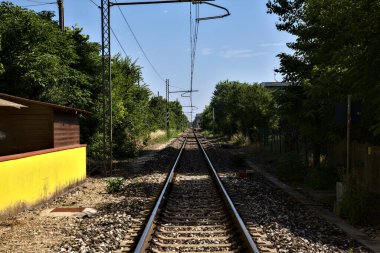 Yazın kırsalda bir grup evin yanında demiryolu hattı var.