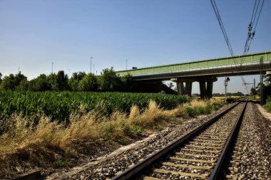 Yazın İtalya kırsalında bir viyadük 'ün yanındaki tren yolu.