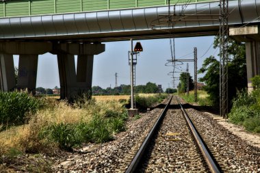 Yazın İtalya kırsalında bir viyadük 'ün yanındaki tren yolu.