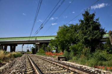 Yazın İtalya kırsalında bir viyadük 'ün yanındaki tren yolu.