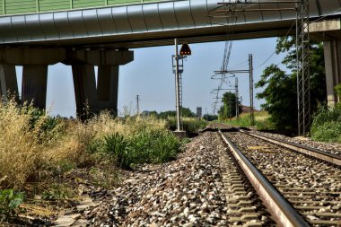 Yazın İtalya kırsalında bir viyadük 'ün yanındaki tren yolu.