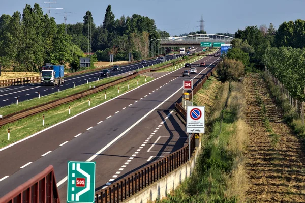 Kırsal kesimdeki İtalyan otoyolu yazın günbatımında bir köprünün üstünden görülüyor.