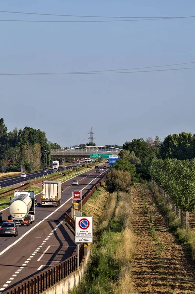 Kırsal kesimdeki İtalyan otoyolu yazın günbatımında bir köprünün üstünden görülüyor.