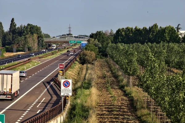 Kırsal kesimdeki İtalyan otoyolu yazın günbatımında bir köprünün üstünden görülüyor.