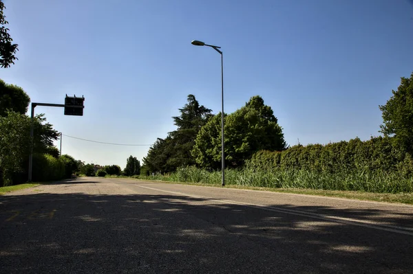 Yazın açık bir günde İtalya kırsalında boş bir yol.