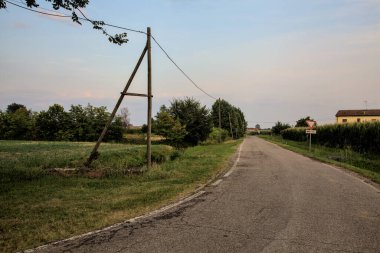 Yazın günbatımında İtalya kırsalında tarlalarla çevrili bir yol.