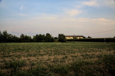 Gün batımında uzakta bir kır evi ile tehdit edilmiş.