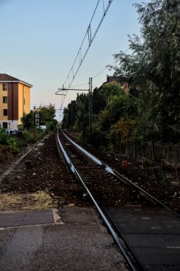 Tren yolu gün batımında bir yerleşim alanından geçiyor.