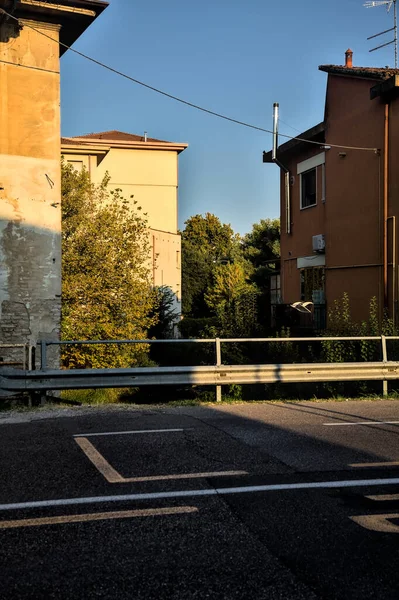 Gün batımında yerleşim alanındaki binalarla çevrili bir su deresi üzerinde yol ve köprü.