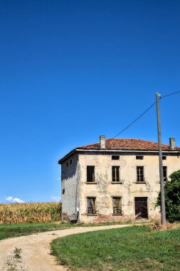 Terk edilmiş bir malikane, yazın İtalya kırsalında mısır tarlalarıyla çevrili bir ahır.