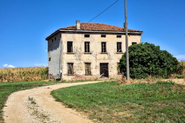 Terk edilmiş bir malikane, yazın İtalya kırsalında mısır tarlalarıyla çevrili bir ahır.