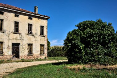 Terk edilmiş bir malikane, yazın İtalya kırsalında mısır tarlalarıyla çevrili bir ahır.