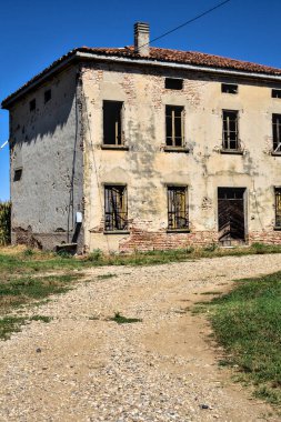 Terk edilmiş bir malikane, yazın İtalya kırsalında mısır tarlalarıyla çevrili bir ahır.