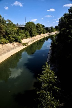 Açık bir günde İtalya kırsalında ağaçlarla çevrili saptırma kanalı