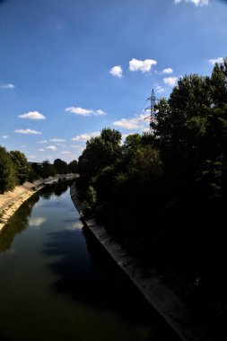 Açık bir günde İtalya kırsalında ağaçlarla çevrili saptırma kanalı
