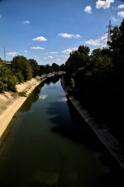Açık bir günde İtalya kırsalında ağaçlarla çevrili saptırma kanalı