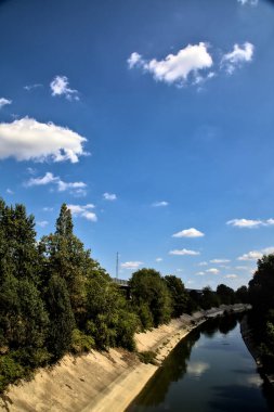 Açık bir günde İtalya kırsalında ağaçlarla çevrili saptırma kanalı