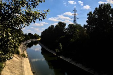 Açık bir günde İtalya kırsalında ağaçlarla çevrili saptırma kanalı