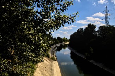 Açık bir günde İtalya kırsalında ağaçlarla çevrili saptırma kanalı
