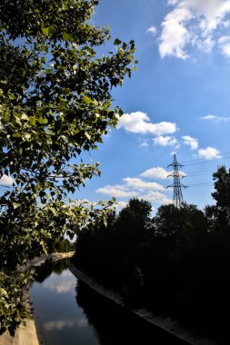 Açık bir günde İtalya kırsalında ağaçlarla çevrili saptırma kanalı