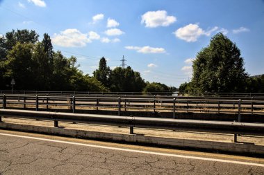 Açık bir günde bir geçitten görünen bölünmüş şeritli bir köprü.