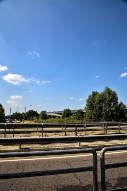 Açık bir günde bir geçitten görünen bölünmüş şeritli bir köprü.