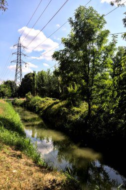İtalya 'nın kırsal kesimlerinde elektrik direği olan bir su akıntısıyla çevrili toprak yol.