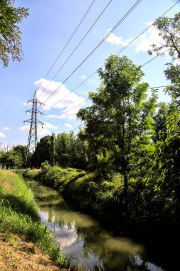 İtalya 'nın kırsal kesimlerinde elektrik direği olan bir su akıntısıyla çevrili toprak yol.