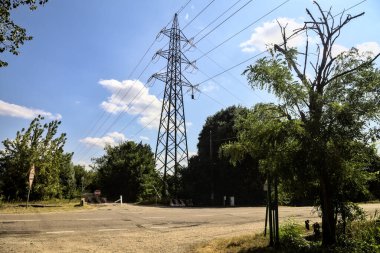 Kırsal kesimdeki bir parkta bir direkle yol ve toprak yol arasında geçiyor.