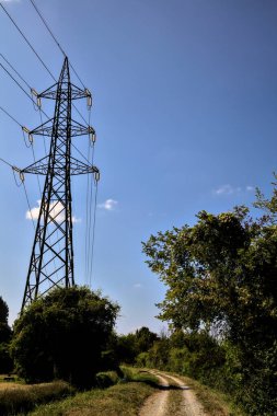 İtalya 'nın kırsal kesimlerinde elektrik direği olan bir su akıntısıyla çevrili toprak yol.