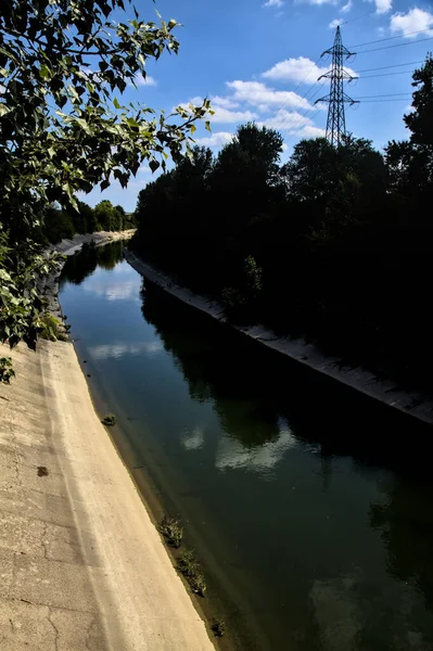 Açık bir günde İtalya kırsalında ağaçlarla çevrili saptırma kanalı