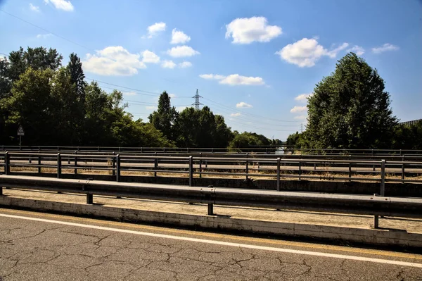 Açık bir günde bir geçitten görünen bölünmüş şeritli bir köprü.