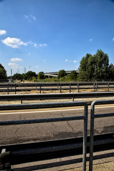 Açık bir günde bir geçitten görünen bölünmüş şeritli bir köprü.